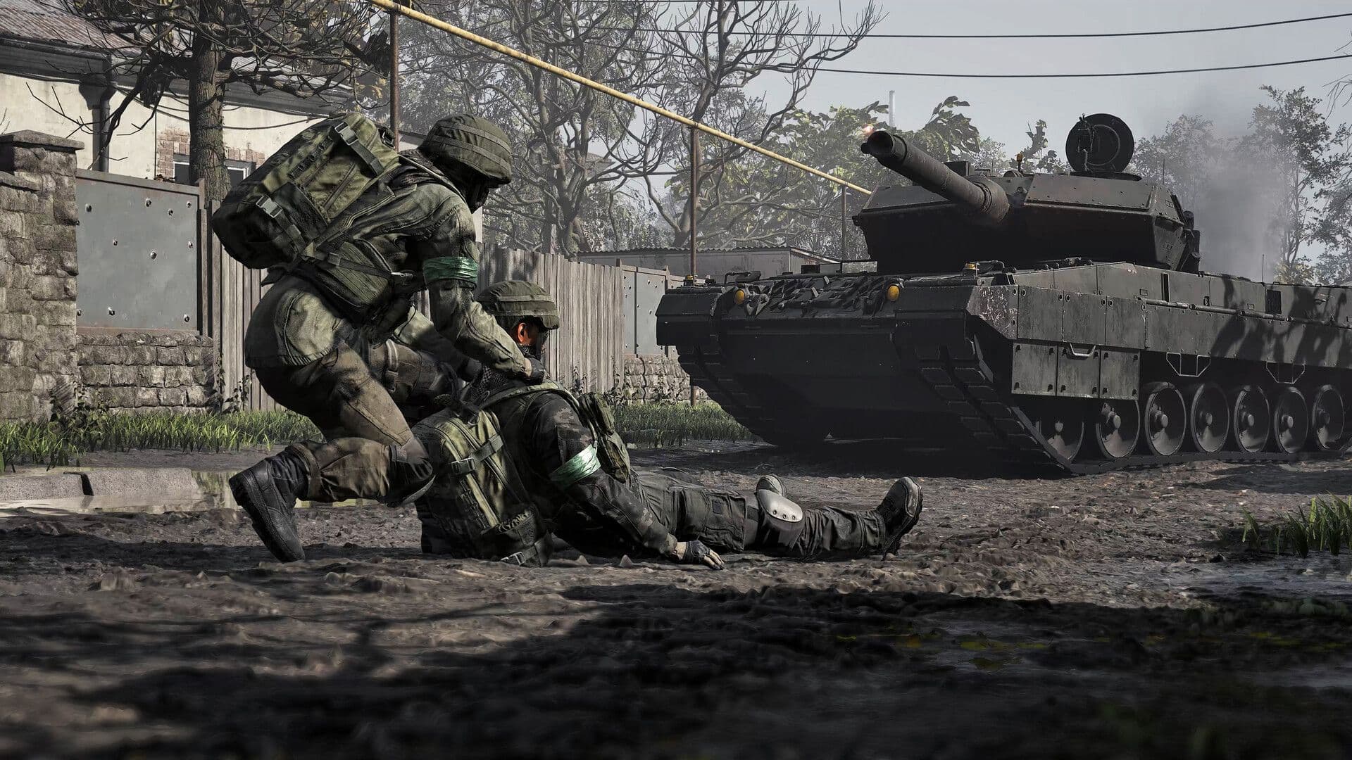 A Medic kneels over a downed teammate in a village street with a tank behind them