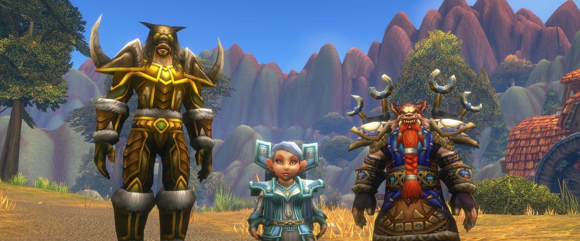 A Tauren, a Gnome and a Dwarf in World of Warcraft: Forever gear standing on a road beneath red canyon peaks