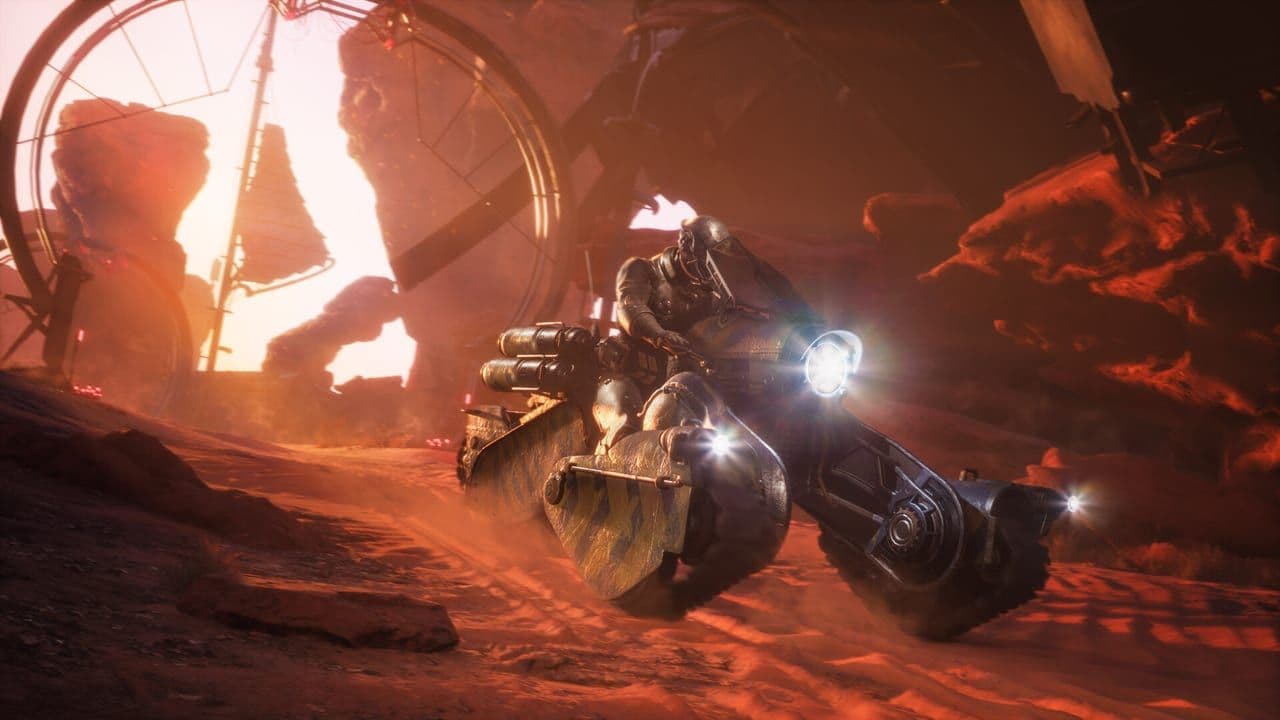 A heavy wheeled vehicle drives through a red canyon in Dune: Awakening