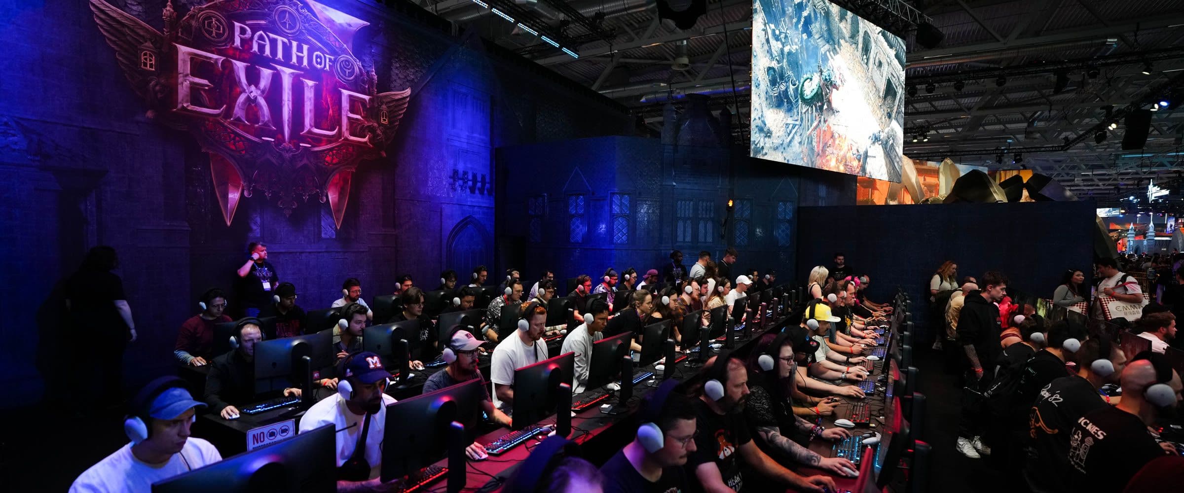 Rows of players at Path of Exile 2 demo stations under a giant Path of Exile logo at Grinding Gear Games' gamescom booth
