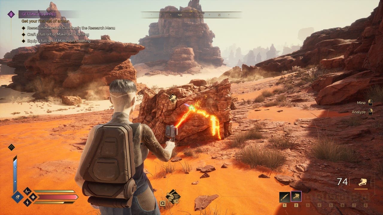 A player crouches beside glowing orange salvage among red rocks in Dune: Awakening